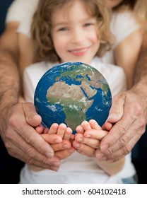 Family holding 3D planet in hands. Earth day holiday concept. Elements of this image furnished by NASA