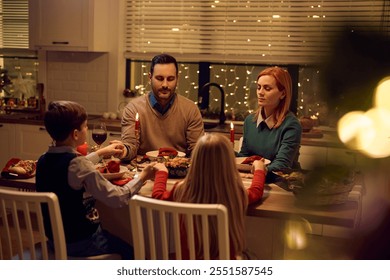 Family holding hands while saying grace during Christmas dinner at dining table. - Powered by Shutterstock