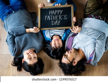 Family holding a phrase Happy Father's Day - Powered by Shutterstock