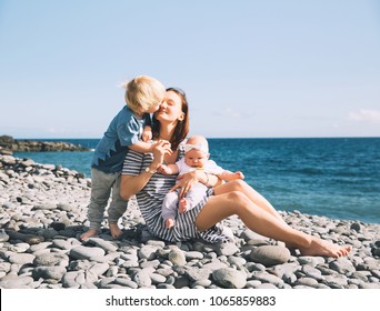 Family holiday on Tenerife, Spain. Mother with children outdoors on ocean. Portrait travel tourists - mom with kids. Positive human emotions, active lifestyles. Happy young family on sea beach - Powered by Shutterstock