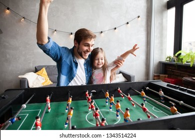 Family Holiday And Togetherness. Father And Daughter Playing Table Football At Home