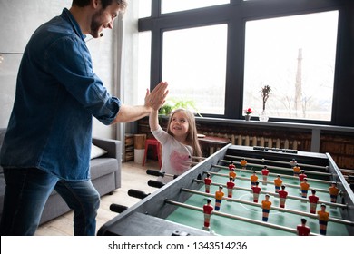 Family Holiday And Togetherness. Father And Daughter Playing Table Football At Home