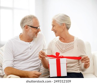 family, holidays, christmas, age and people concept - happy senior couple with gift box over white room background - Powered by Shutterstock