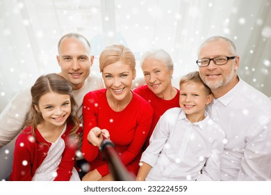 Family, Holidays, Generation, Christmas And People Concept - Smiling Family With Camera And Selfie Stick Taking Picture At Home