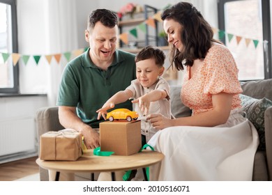 Family, Holidays And People Concept - Happy Mother, Father And Little Son Opening Birthday Presents At Home Party