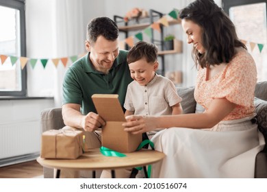 Family, Holidays And People Concept - Happy Mother, Father And Little Son Opening Birthday Presents At Home Party