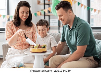 family, holidays and people concept - portrait of happy mother, father and little son with birthday cake sitting on sofa at home party - Powered by Shutterstock