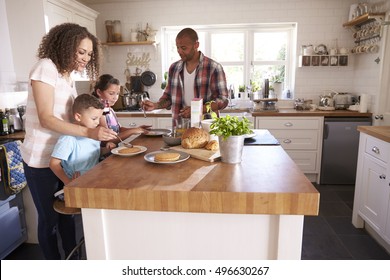 Family At Home Eating Breakfast In Kitchen Together