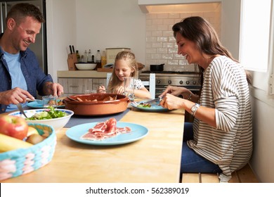 Family At Home In Eating Meal Together