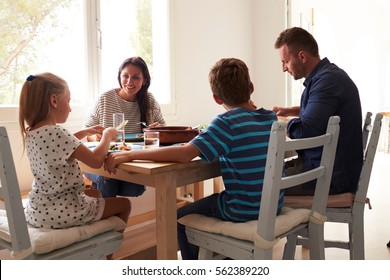 Family At Home In Eating Meal Together