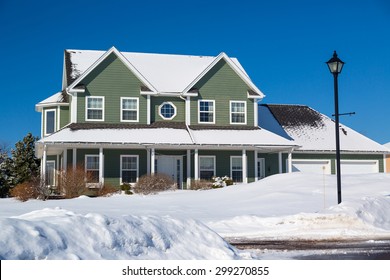 A family home in a north American suburb covered in snow.