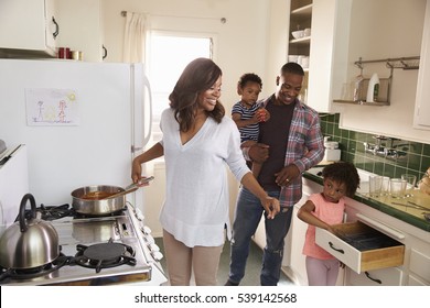 Family At Home Preparing Meal In Kitchen Together