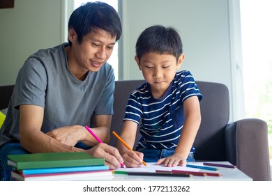 Family and homework concept. Happy father and son with book writing to study at home. - Shutterstock ID 1772113262