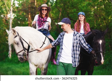 Family Horseback Riding In Forest