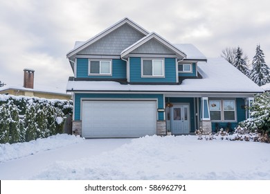 Family House With Front Yard In Snow. Residential House On Winter Cloudy Day