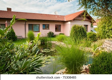 Family house with pond in garden - rear view