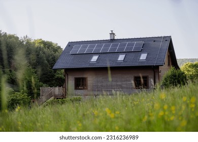 Family house with solar panels on the roof at meadow. - Shutterstock ID 2316236989
