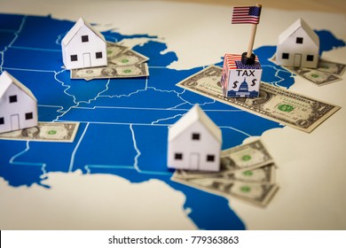 Family Houses With Dollar Bills And Central Goverment Tax Over A US Map.USA Finance And Economy Concept Related To The Tax Cuts And Jobs Act. Approved By The Senate In December