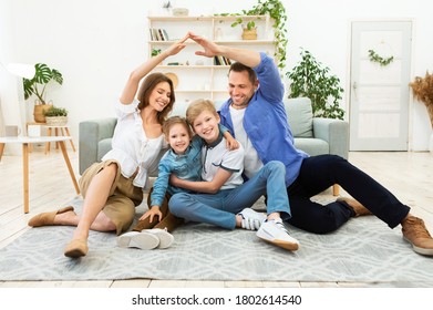 Familienwohnungskonzept. Eltern, die symbolische Dächer an ihren Kindern machen, die zu Hause auf dem Boden sitzen.
