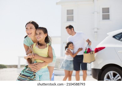 Family hugging in sunny driveway - Powered by Shutterstock