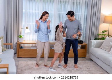 Family Husband Wife And Daughter Stand Happy Dancing Exercise Together On The Carpet In The Leaving Room