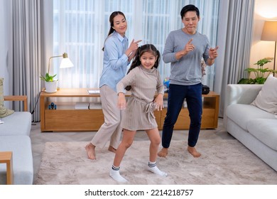 Family Husband Wife And Daughter Stand Happy Dancing Exercise Together On The Carpet In The Leaving Room