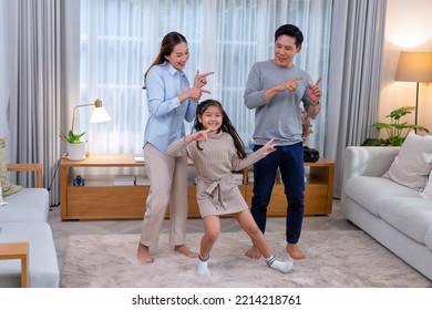 Family Husband Wife And Daughter Stand Happy Dancing Exercise Together On The Carpet In The Leaving Room