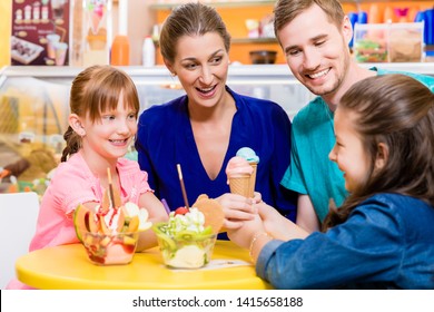 Family In Ice Cream Parlor Enjoying A Sweet Dessert 