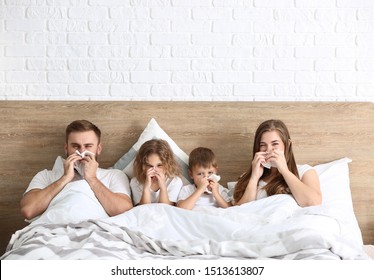 Family Ill With Flu In Bed At Home