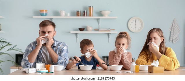 Family Ill With Flu Eating Chicken Soup In Kitchen