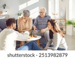 Family, including elderly parents, adult children, is bonding together at home, playing chess on the sofa. This moment captures happiness and togetherness, bridging generations through the game.