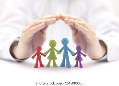 Family insurance concept with colorful family figurines covered by hands - Shutterstock ID 1645083355