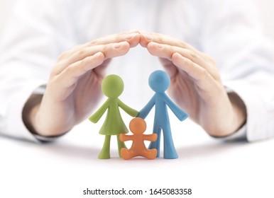 Family insurance concept with colorful family figurines covered by hands - Shutterstock ID 1645083358