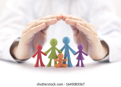 Family insurance concept with colorful family figurines covered by hands - Shutterstock ID 1645083367