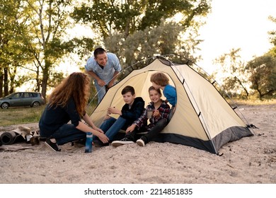 Family Interacting Outside The Tent At Campsite. Happy Big Family Camping At Sunset. Enjoy Time With Family. Travel, Adventure, Vacation With Kids Concept