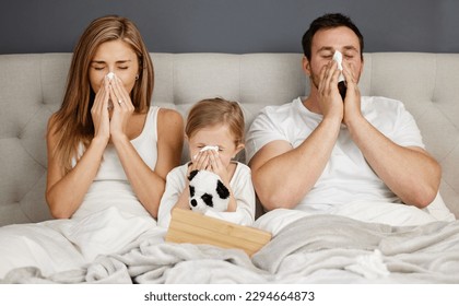 Family isolation session. Shot of a family blowing their noses while sick at home. - Powered by Shutterstock