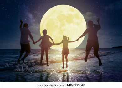 Family Jumping On Beach And Watching The Moon.Celebrate Mid Autumn Festival Concept