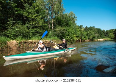 Family Kayak Trip. An Elderly Married Couple Rowing A Boat On The River, A Water Hike, A Summer Adventure. Age-related Sports, Mental Youth And Health, Tourism, Active Old Age