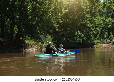 Family Kayak Trip. An Elderly Married Couple Rowing A Boat On The River, A Water Hike, A Summer Adventure. Age-related Sports, Mental Youth And Health, Tourism, Active Old Age