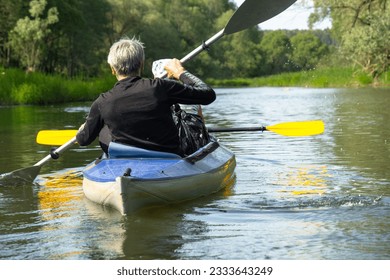 Family kayak trip for seigneur and senora. An elderly married couple rowing a boat on the river, a water hike, a summer adventure. Age-related sports, mental youth and health, tourism, active old age - Powered by Shutterstock