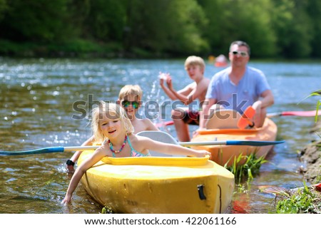 Family kayaking on the river. Active father with children, two teenage boys and little girl, having fun together enjoying adventurous experience with kayak on a sunny day during summer vacation