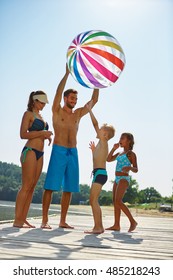 Family With Kids And A Beach Ball At A Lake In Summer