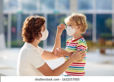 Familia con niños con mascarillas en centro comercial o aeropuerto. Madre e hijo usan máscara durante el brote de coronavirus y gripe. Protección contra virus y enfermedades, desinfectante manual en un lugar público abarrotado.