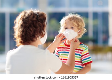 Family With Kids In Face Mask In Shopping Mall Or Airport. Mother And Child Wear Facemask During Coronavirus And Flu Outbreak. Virus And Illness Protection, Hand Sanitizer In Public Crowded Place.