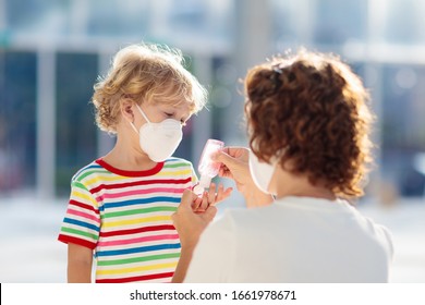 Familie mit Kindern in Gesichtsmaske im Einkaufszentrum oder Flughafen. Mutter und Kind tragen Gesichtsmaske während des Ausbruchs von Coronavirus und Grippe. Virus- und Krankheitsschutz, Handanisierer an öffentlichen Plätzen.