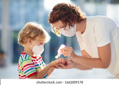 Familie mit Kindern in Gesichtsmaske im Einkaufszentrum oder Flughafen. Mutter und Kind tragen Gesichtsmaske während des Ausbruchs von Coronavirus und Grippe. Virus- und Krankheitsschutz, Handanisierer an öffentlichen Plätzen.