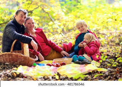 Family with kids having picnic in the forest. Mother, father and two children enjoying warm sunny autumn day in the nature. Fall fun outdoors. Selected focus on boy. - Powered by Shutterstock