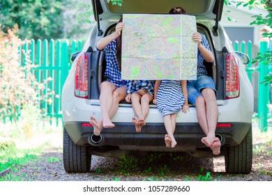 Family With Kids Looking At Map While Travel By Car