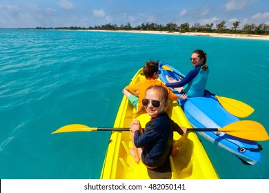 Family With Kids Paddling On Colorful Kayaks At Tropical Ocean Water During Summer Vacation