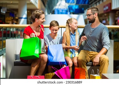 Family With Kids Shopping In Mall Having A Break